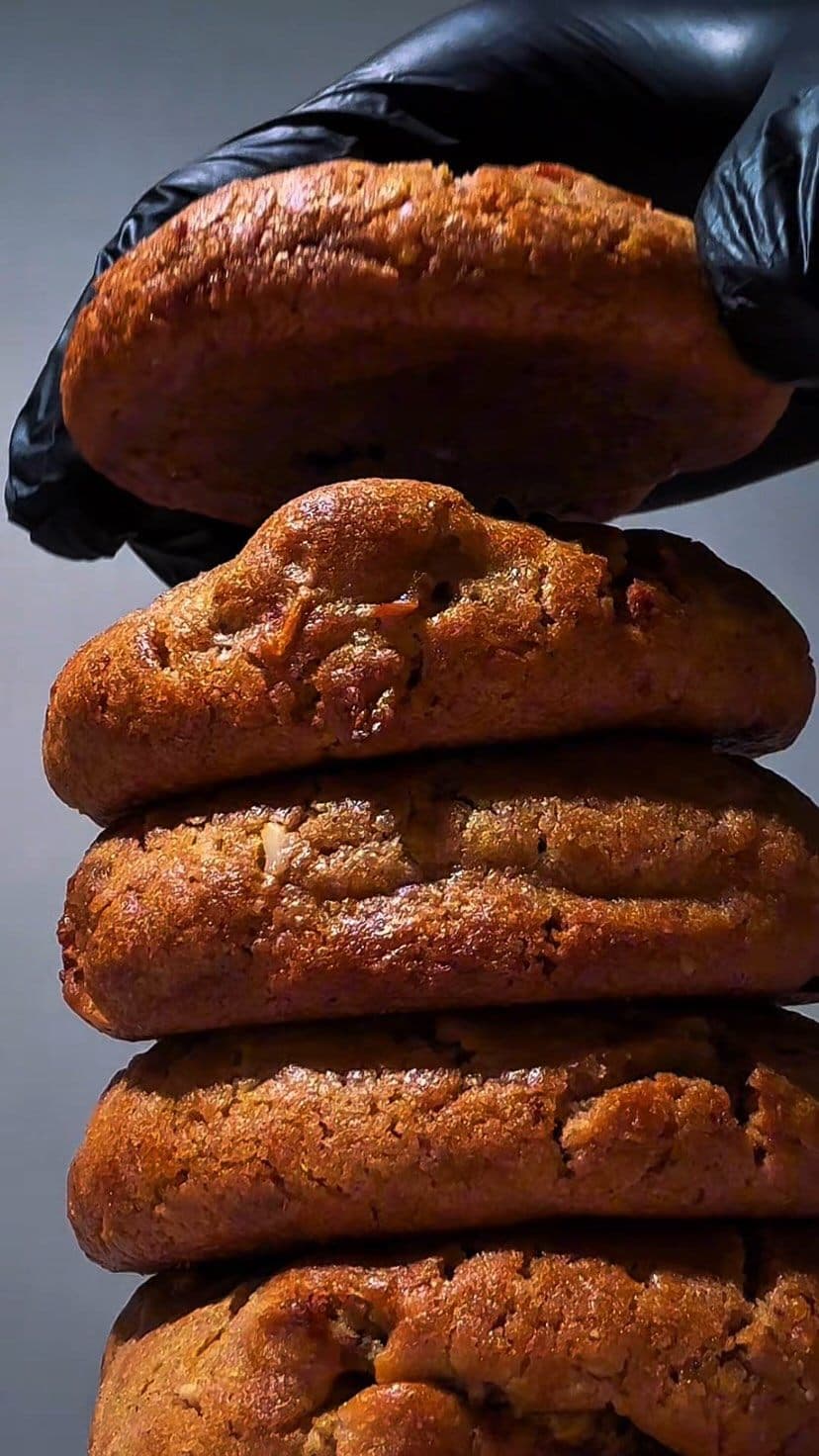 A stack of Madini Cookies held up by a gloved hand