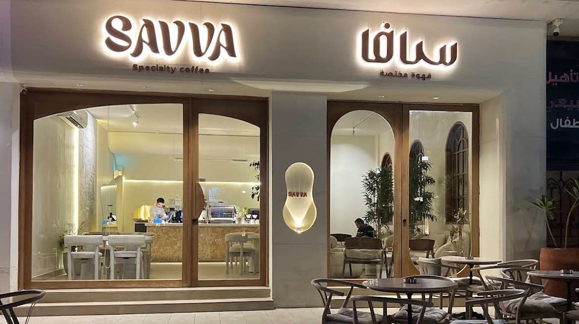 SAVVA's lit storefront on Bir Uthman at night, with terrace seating