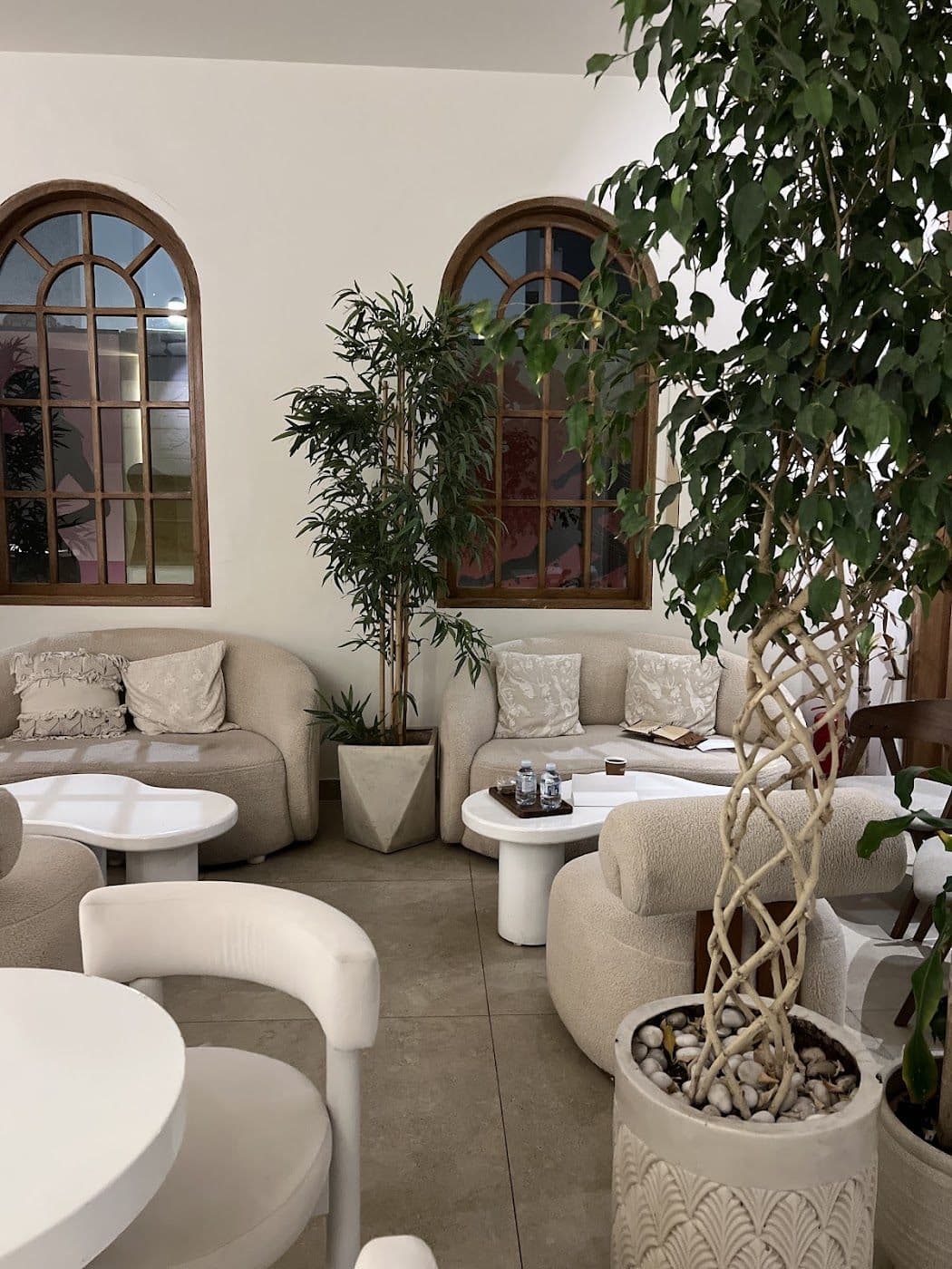 SAVVA's lounge — arched wooden windows, cream seating and large plants